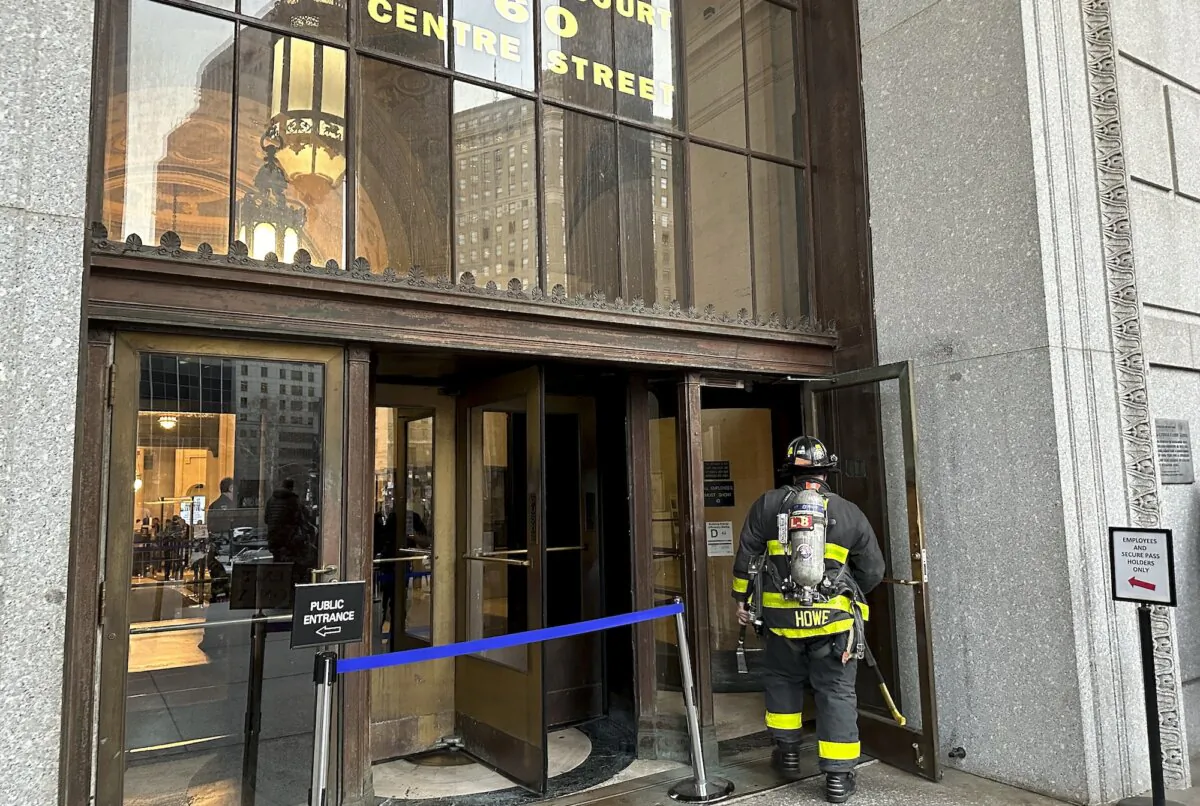 A New York firefighter steps into the main entrance of New York Supreme Court on Dec. 13, 2023. (AP Photo/Jennifer Peltz)