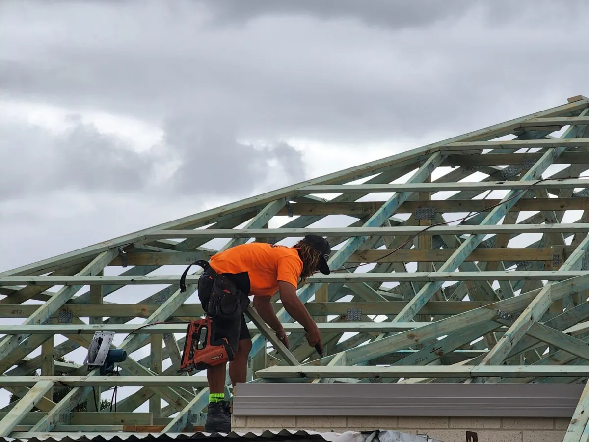 A man works on the roof of a new home in Albany, Western Australia, on Dec. 14, 2023. (Susan Mortimer/The Epoch Times)