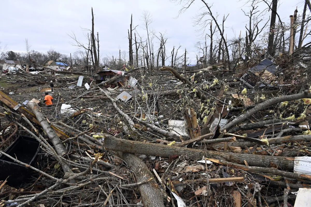A man cuts trees in the rubble of a mobile home neighborhood in Clarksville, Tenn., on Dec. 10, 2023. (Mark Zaleski/AP Photo)