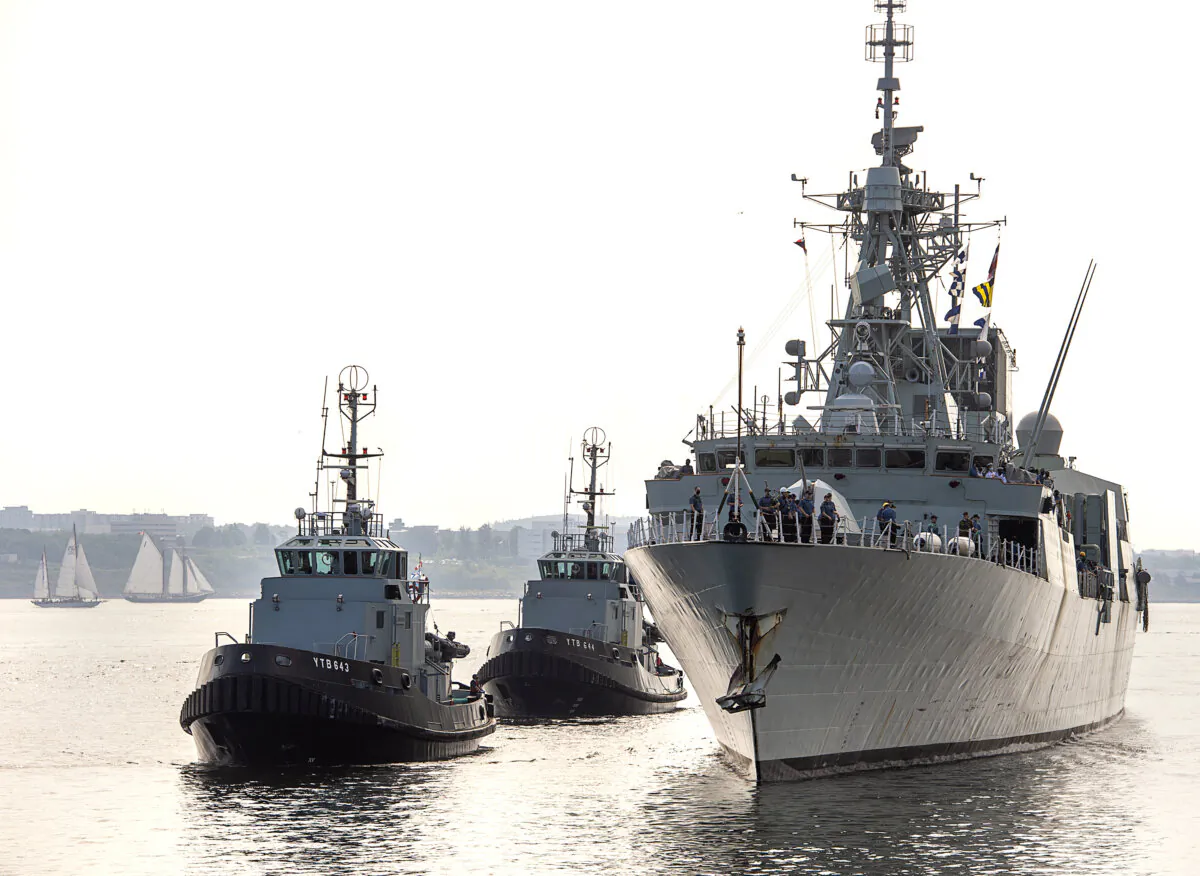The HMCS Fredericton, guided by tugs, returns to Halifax after a six-month deployment in the Mediterranean Sea, on July 28, 2020. (The Canadian Press/Andrew Vaughan)