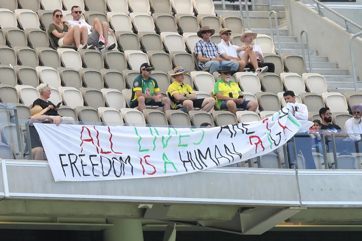 A pro Palestine banner is removed by security during Day 4 of the first Test match between Australia and Pakistan at Optus Stadium in Perth, Western Australia on Dec. 17, 2023. (AAP Image/Richard Wainwright)