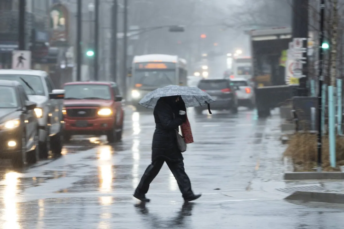 A pedestrian shields themselves from rain and wind during a rainfall warning in Halifax on Jan. 26 2023. (The Canadian Press/Darren Calabrese)