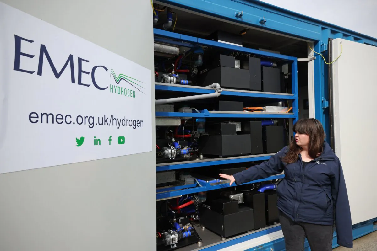 European Marine Energy Centre (EMEC) Technician Jerry Gibson explains about the hydrogen fuel cell in the harbour at Kirkwall, Orkney on Sept. 6, 2021. EMEC produces "green" hydrogen from renewable sources via a tidal turbine and electrolysis. (Adrian Dennis/AFP via Getty Images)