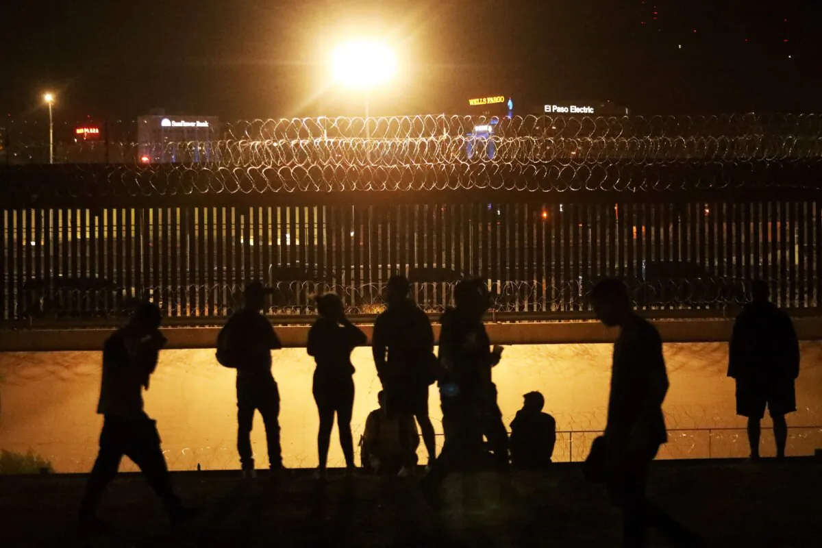 Immigrants wait to be received across a railroad bridge at the border between El Paso, Texas, and Ciudad Juarez, state of Chihuahua, Mexico, on Aug. 7, 2023. (Herika Martinez/AFP via Getty Images)
