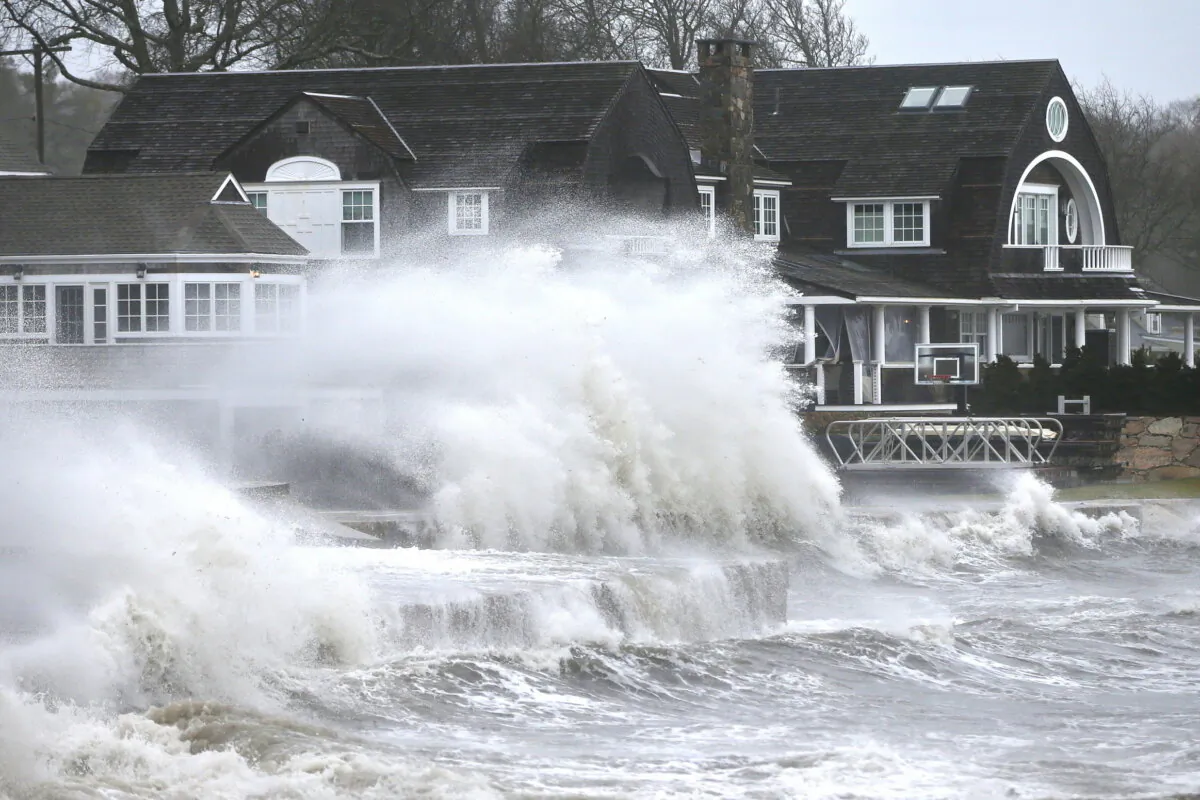 High winds drive surf into a retaining wall in front of a residence in Mattapoisett, Mass. on Dec. 18, 2023, as a storm makes its away across the region. (Peter Pereira/The Standard-Times via AP)