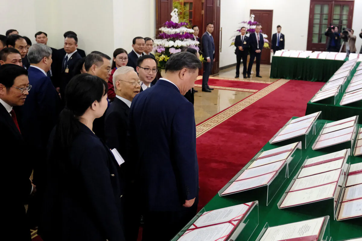 Chinese President Xi Jinping (C) and Vietnamese Communist Party General Secretary Nguyen Phu Trong (centre L) walk past signed agreements displayed at the Central Office of the Communist Party of Vietnam in Hanoi on Dec. 12, 2023. (Minh Hoang/POOL/AFP via Getty Images)