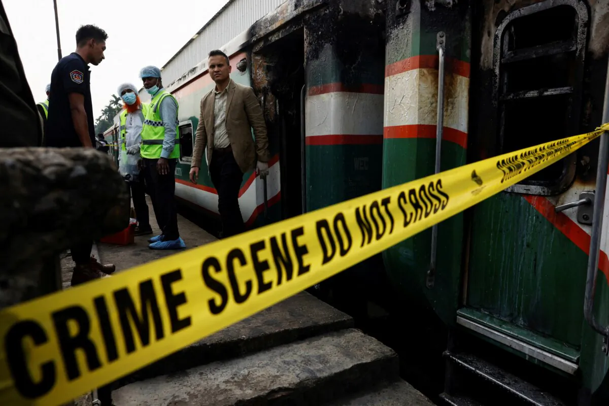 Crime Scene Unit members inspect the passenger train that was set on fire during a countrywide strike called by the Bangladesh Nationalist Party, ahead of the general election, in Dhaka, Bangladesh, on Dec. 19, 2023. (Mohammad Ponir Hossain/Reuters)