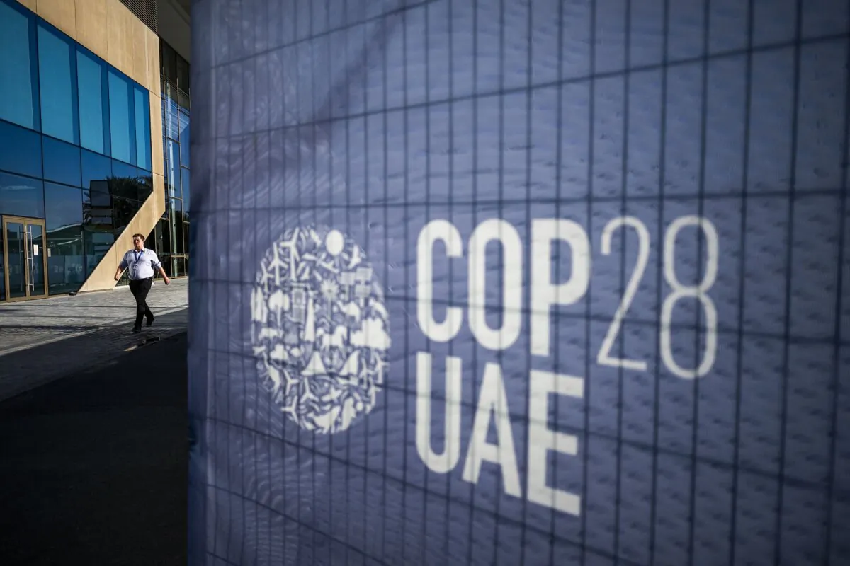 A man walks past a COP28 sign at the venue of the United Nations climate summit in Dubai on Nov. 30, 2023. (Jewel Sawad/AFP via Getty Images)