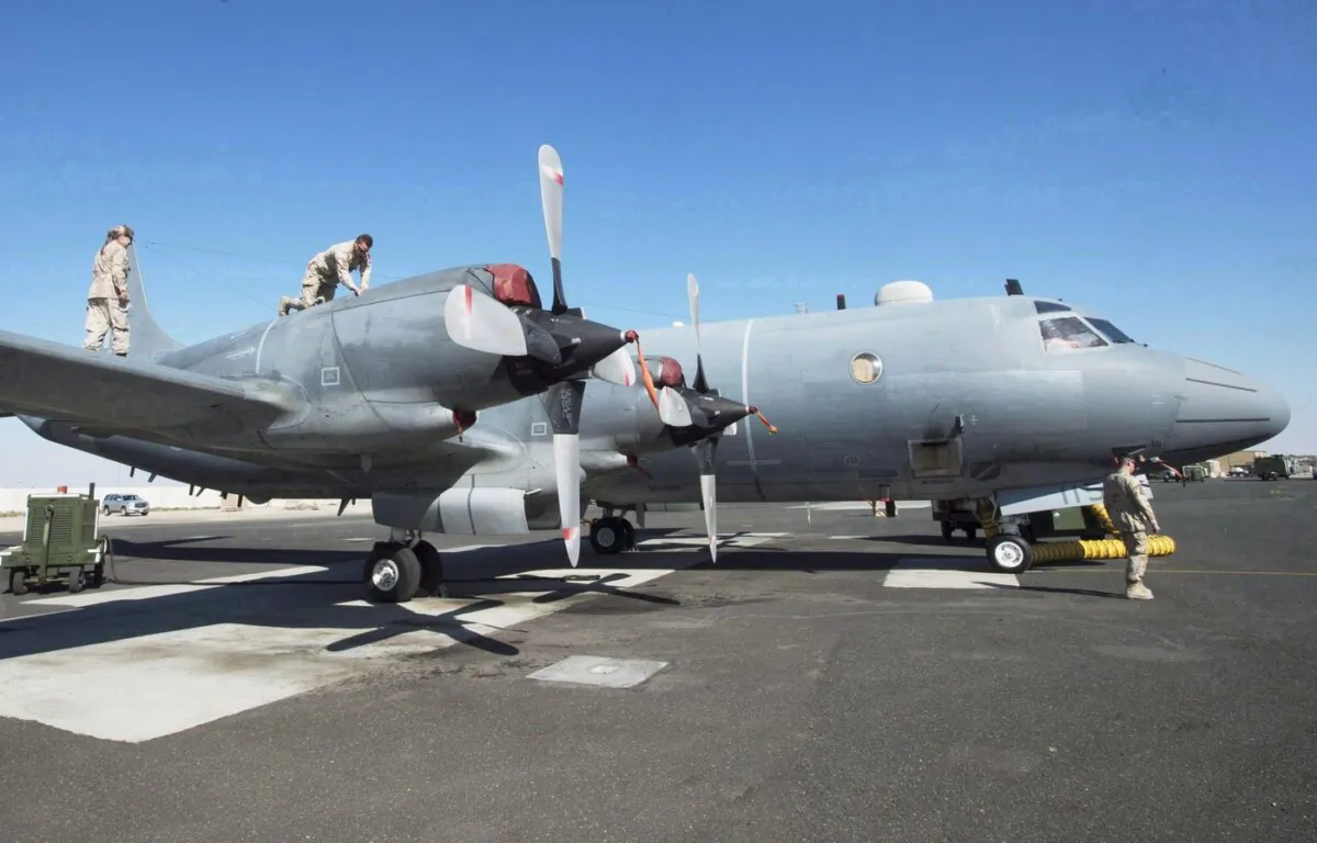 Members of the Canadian Forces work on a CP-140 Aurora surveillance plane at the Canadian Forces base in the Persian Gulf, on Feb. 19, 2017. (The Canadian Press/Ryan Remiorz)
