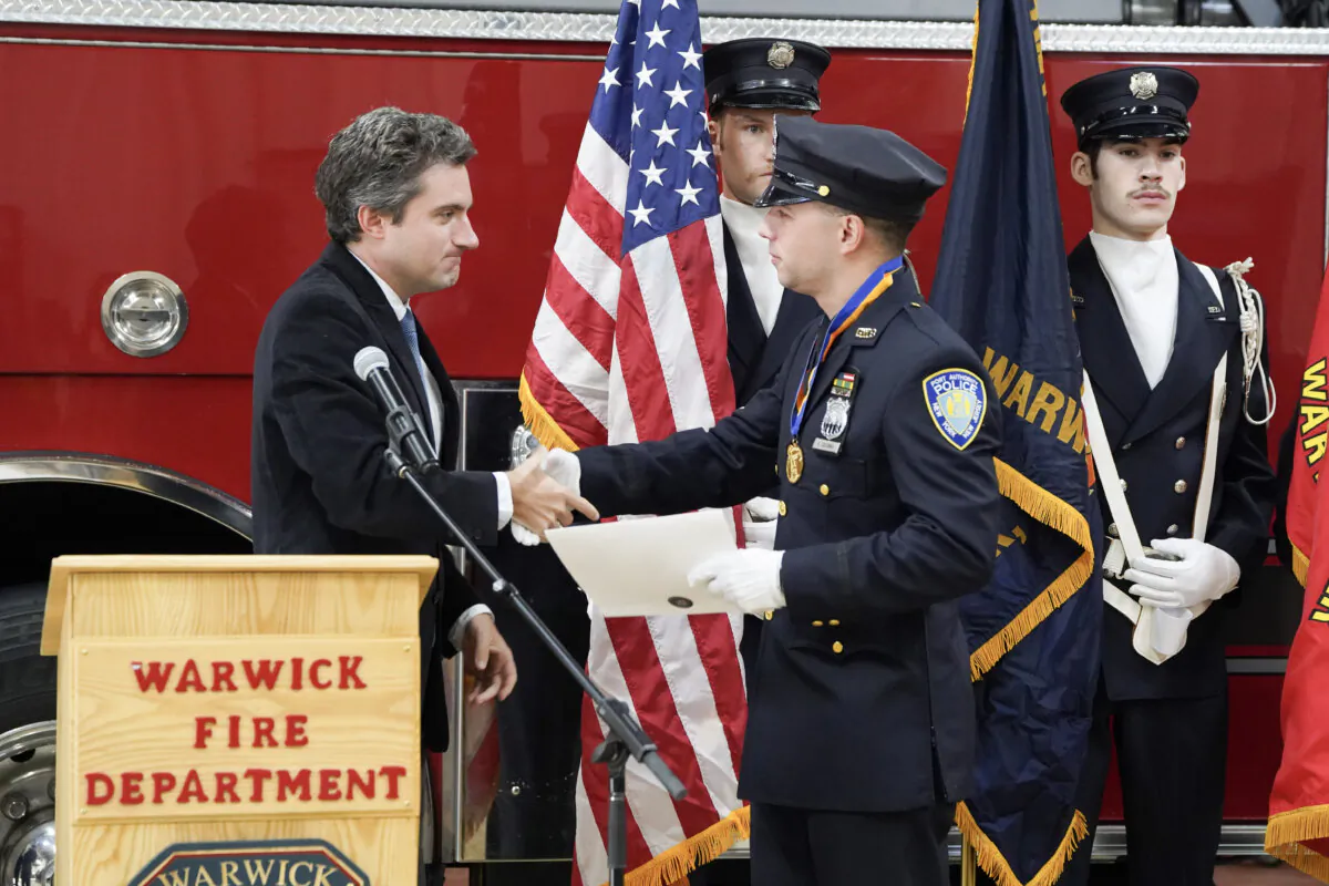 State Sen. James Skoufis presents the Liberty Award to Kevin Colomba at the Warwick Fire Department in Warwick, N.Y., on Dec. 19, 2023. (Cara Ding/The Epoch Times)