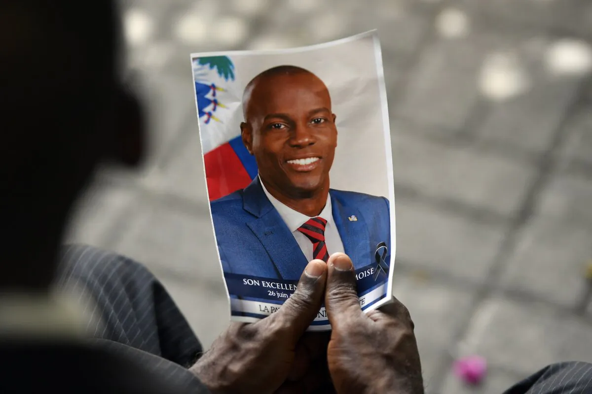 A person holds a photo of late Haitian President Jovenel Moise during his memorial ceremony at the National Pantheon Museum in Port-au-Prince, Haiti, on July 20, 2021. (Matias Delacroix/AP Photo)