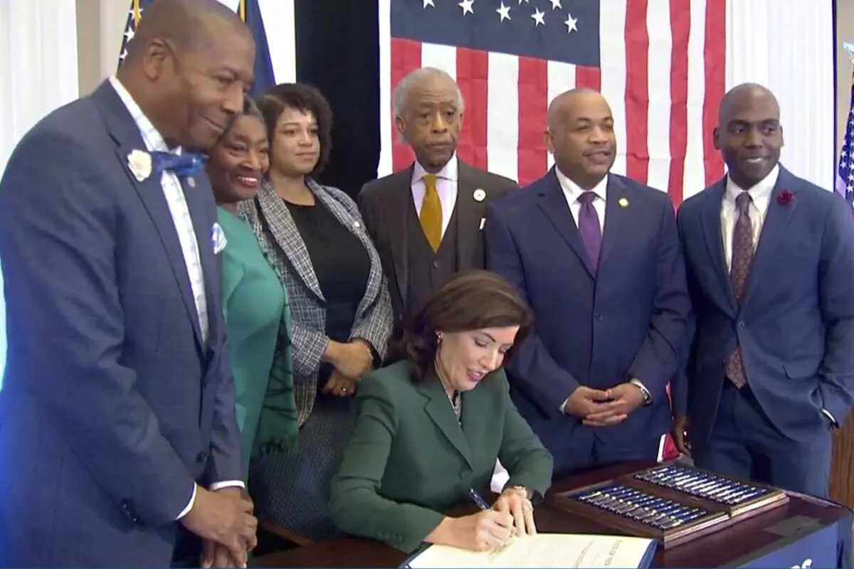New York Gov. Kathy Hochul is signing a bill in Albany, N.Y., on Dec. 19, 2023, to create a commission tasked with considering reparations to address the persistent, harmful effects of slavery in the state. (Office of the Governor via AP)