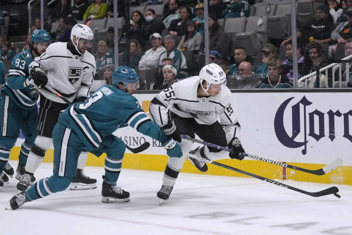 San Jose Sharks defenseman Henry Thrun (L) reaches for the puck next to Los Angeles Kings right wing Quinton Byfield (55) during the second period of an NHL hockey game in San Jose, Calif., on Dec. 19, 2023. (Jeff Chiu/AP Photo)