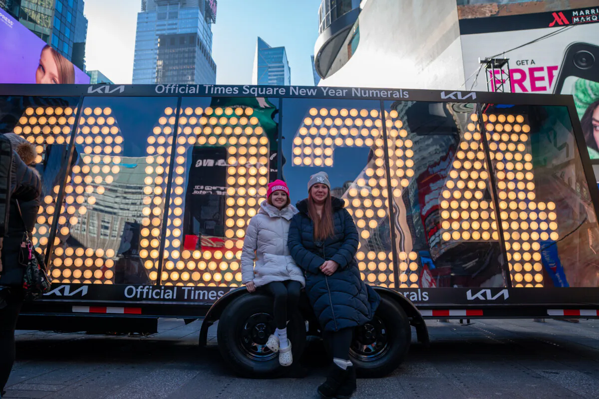 Revelers pose in front of a sign with the 2024 numerals after an illumination ceremony in Times Square in New York on Dec. 20, 2023. (David Dee Delgado/Getty Images)