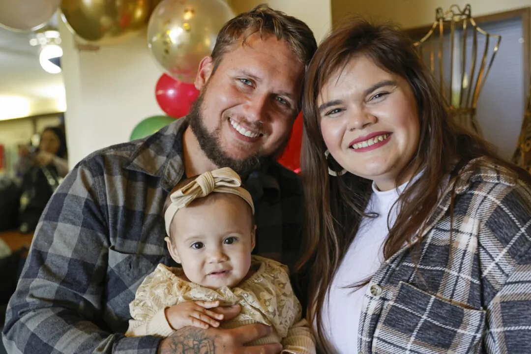 Alan Shurtleff (L), Morgan Shurtleff (R) and their daughter, 1-year-old Cora Dibert, pose for a photo at The Bridge Church in Mustang, Okla., on Dec. 2, 2023. (Nate Billings/AP Photo)