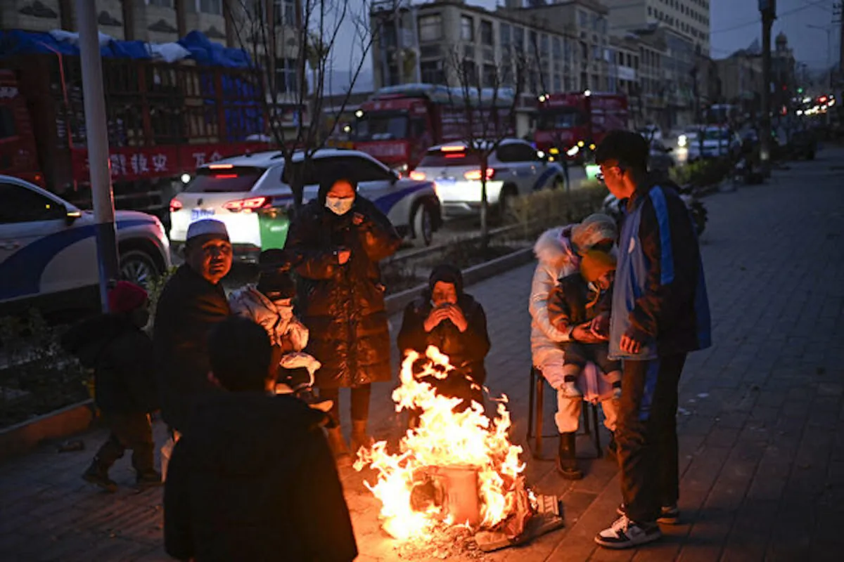 People gather next to a fire on a street after an earthquake in Dahejia, Jishishan County, in northwest China’s Gansu Province on Dec. 19, 2023. (Pedro Pardo/AFP)