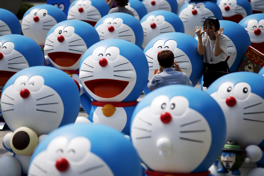 A man takes photographs of his girlfriend posing next to a Doraemon figure during an exhibition in Seoul, South Korea, on Aug. 31, 2015. (Kim Hong-Ji/Reuters)