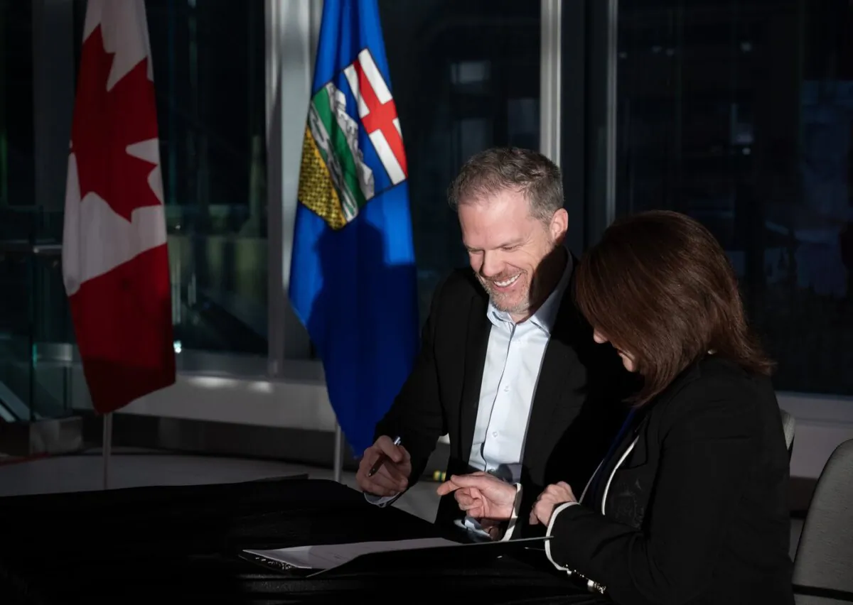 Canada's Minister of Health Mark Holland signs an agreement with Adriana LaGrange, minister of health for Alberta, in Calgary on Dec. 21, 2023. (The Canadian Press/Todd Korol)