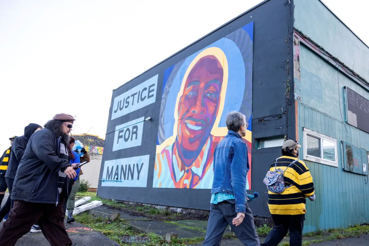 Protesters walk by a mural of Manny Ellis after the verdict is read during the trial of three Tacoma Police officers in the death of Manny Ellis, at Pierce County Superior Court, in Tacoma, Wash., on Dec. 21, 2023. (Maddy Grassy/AP Photo)