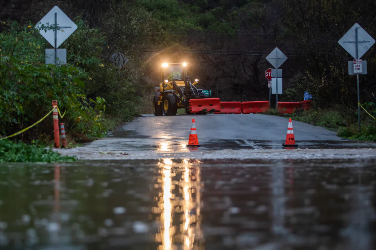 City workers close a road after a creek overflows during heavy rains in Zuma Beach during heavy rains in Malibu, Calif., on Dec. 21, 2023. (Apu Gomes/Getty Images)