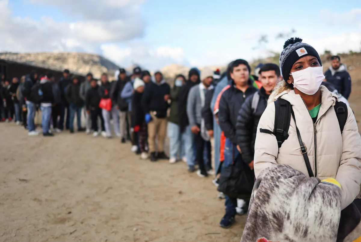 Asylum seeking migrants stand at a makeshift camp along the U.S.-Mexico border as they await processing by the U.S. Border Patrol in Jacumba Hot Springs, Calif., on Dec. 1, 2023. (Mario Tama/Getty Images)