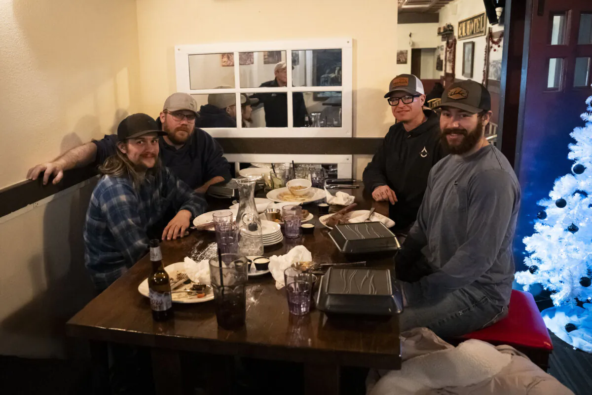 James Harmon (L-R), Brett Smith, Riley Kuntz, and Rocko Mackade enjoy a holiday dinner at Sagas Steakhouse in Williston, N.D., on Dec. 21, 2023, before returning to their mancamp near the Patterson 806 rig, where they will be working 12-hour shifts on Christmas. (Madalina Vasiliu/The Epoch Times)