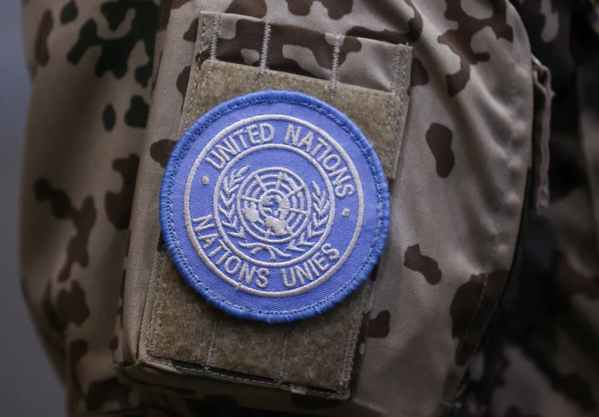 An emblem of the United Nations on the arm of a German armed forces Bundeswehr soldier who had served under the U.N. Multidimensional Integrated Stabilization Mission in Mali after the troops landed at the military air base in Wunstorf, northern Germany, on Dec. 15, 2023. (Ronny Hartmann/ AFP)