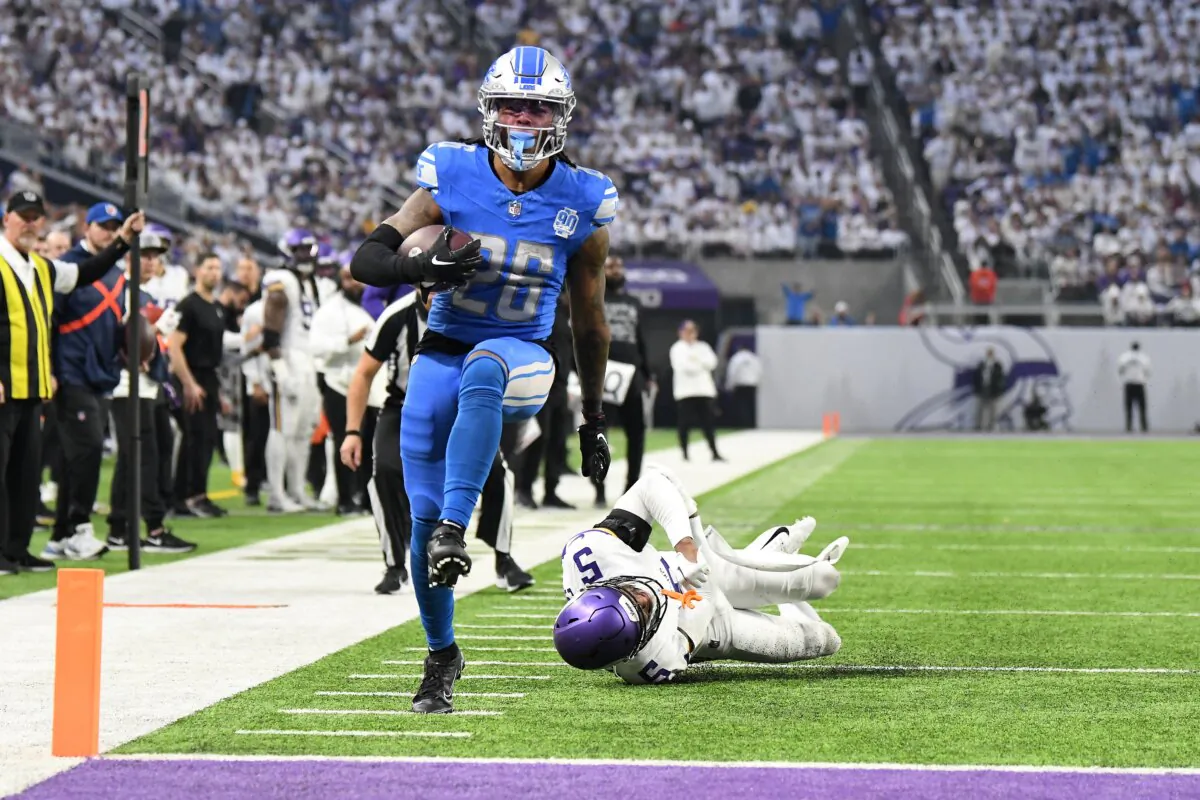Jahmyr Gibbs (26) of the Detroit Lions scores a rushing touchdown against Mekhi Blackmon (5) of the Minnesota Vikings during the second quarter at U.S. Bank Stadium in Minneapolis on Dec. 24, 2023. (Stephen Maturen/Getty Images)