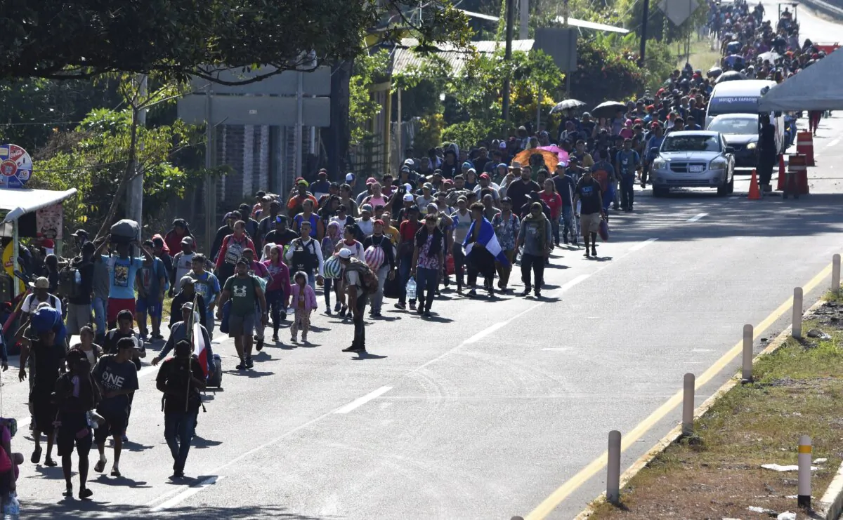Migrants walk along a highway in Huixtla, Mexico, on Dec. 25, 2023. (Edgar H. Clemente/AP Photo)