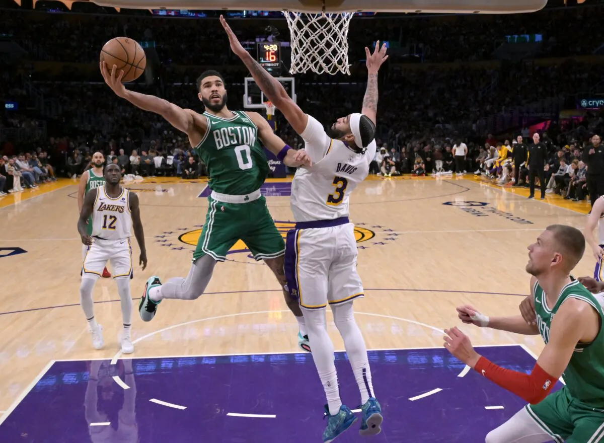 Jayson Tatum (0) of the Boston Celtics drives over Anthony Davis (3) of the Los Angeles Lakers in the second half in Los Angeles on Dec. 25, 2023. (Jayne Kamin-Oncea/Getty Images)