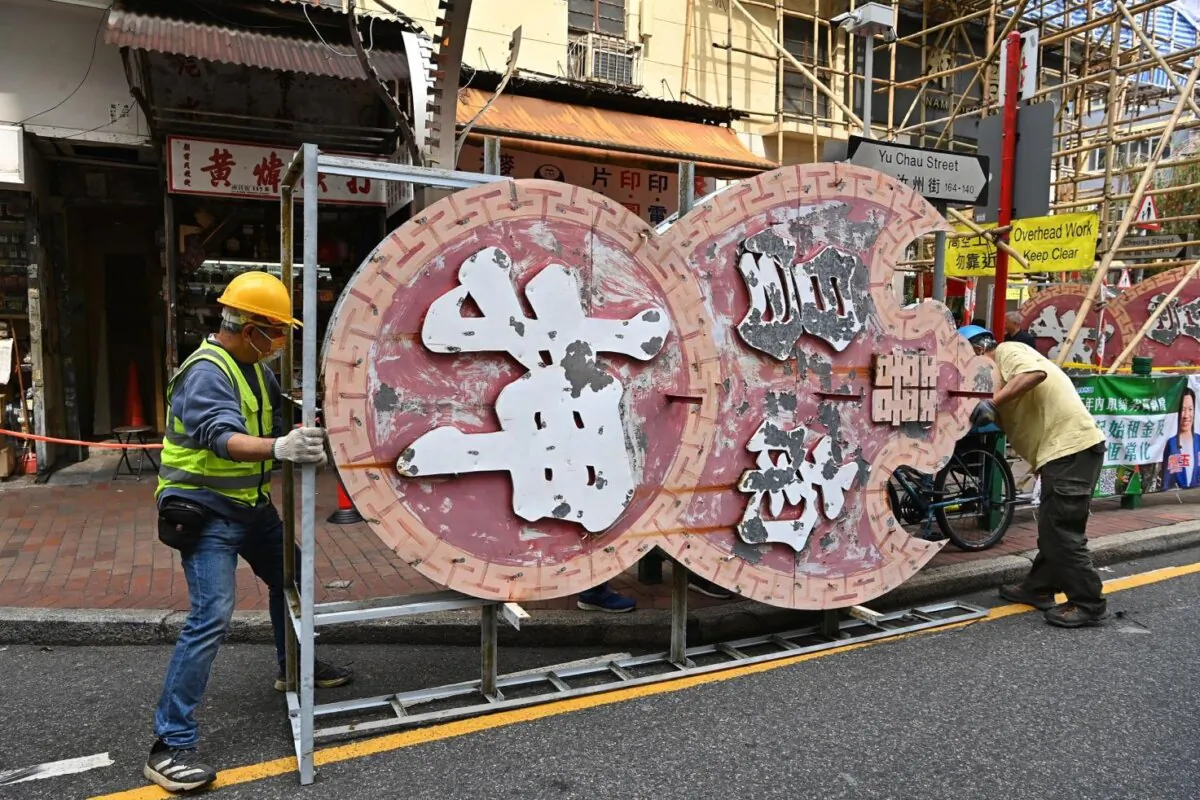 Two giant neon signs hanging aloft in front of a pawn shop in Nam Cheong, Sham Shui Po, displaying the ancient Chinese metaphor "Hanging Bats Draw Money," which had been present for more than half a century, were accused of breaching the Building Ordinance and were removed by contractors on March 14, 2023. (Sung Pi-lung/The Epoch Times)