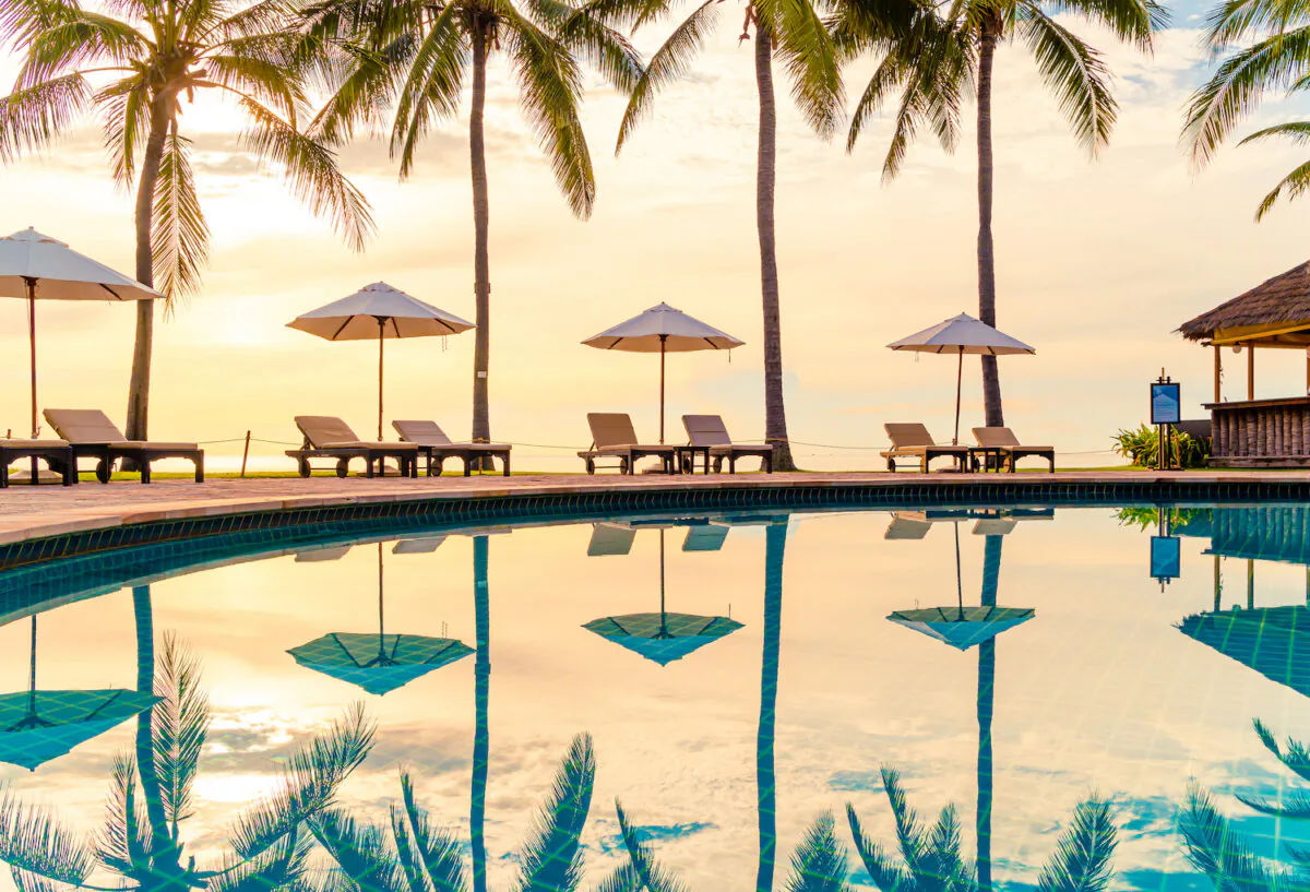 Umbrella and chair around swimming pool in resort hotel for leisure travel. (Dreamstime/TNS)