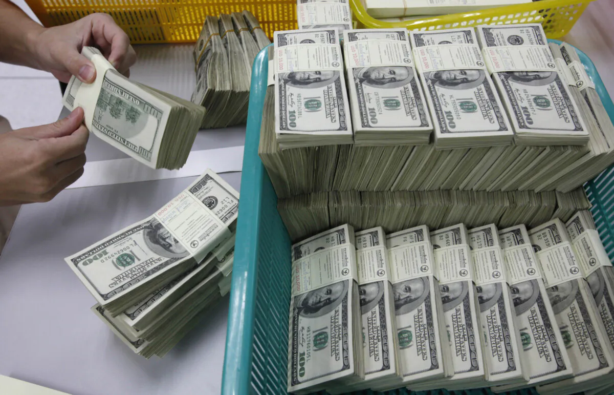 A bank employee counts U.S. hundred dollar bills at Kasikornbank in Bangkok on Jan. 21, 2010. (Sukree Sukplang/Reuters)