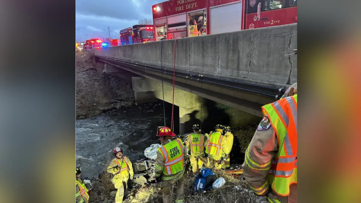 Police rescue a man after finding his damaged vehicle along Interstate 94 near Portage, Ind., on Dec. 26, 2023. (Indiana State Police via AP)