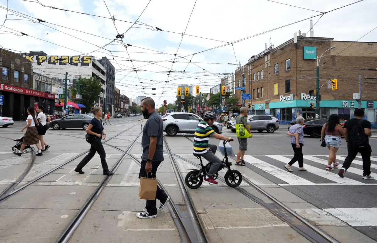 People cross the intersection at Spadina Ave. and Dundas St. in Toronto in a file photo. (The Canadian Press/Nathan Denette)