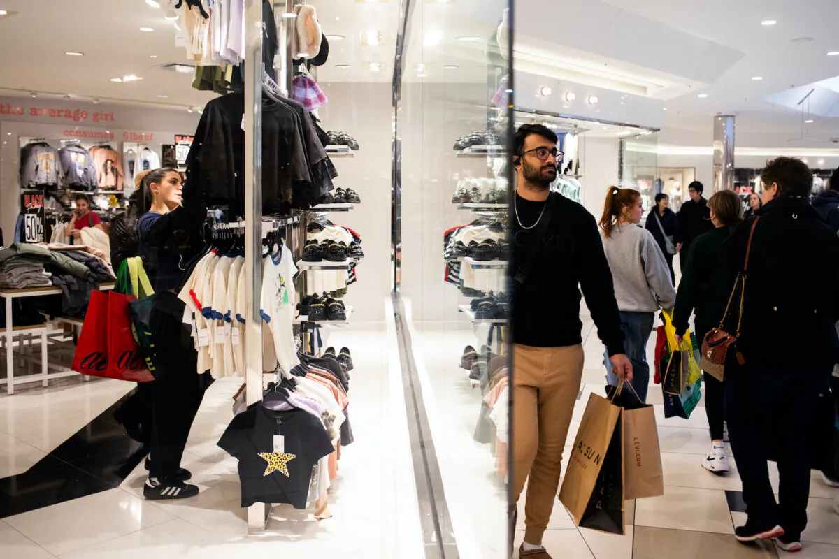 Shoppers look at clothes while others walk around Twelve Oaks Mall in Novi, Mich., on Nov. 24, 2023. (Emily Elconin/Getty Images)