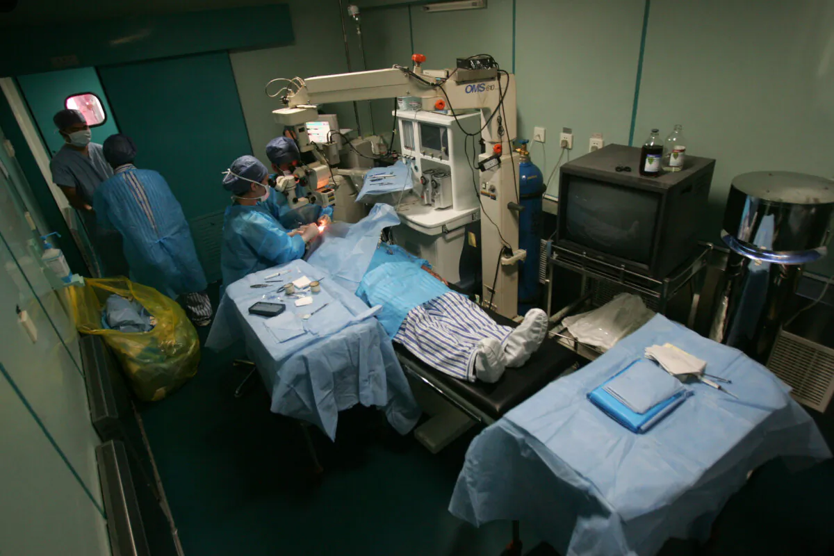 Doctors carry out a free cataract removal surgery for a patient, in Nanyang, Henan Province, China, on May 11, 2008. (Photo by China Photos/Getty Images)
