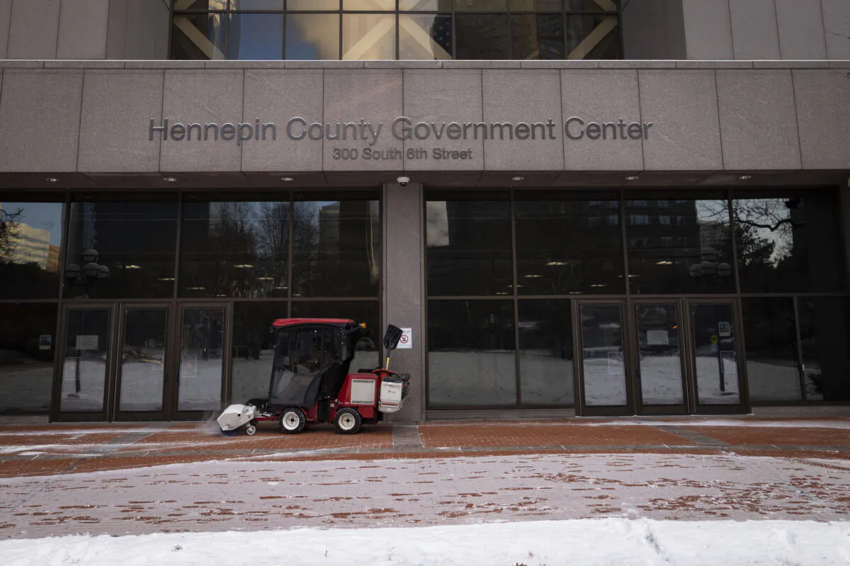 Snow is removed from the entrance of the Hennepin County Government Center in Minneapolis on Dec. 8, 2021. (Christian Monterrosa/AP Photo)