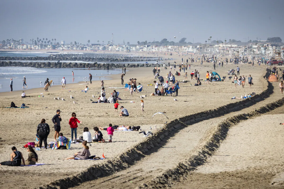 Beachgoers and surfers in Newport Beach, Calif., on Dec. 28, 2023. (John Fredricks/The Epoch Times)