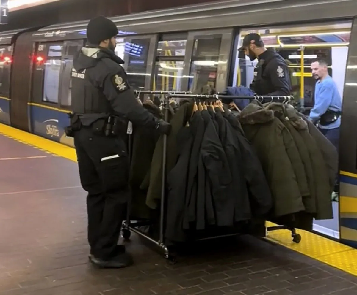 A still from a handout video posted on social media shows Metro Vancouver Transit Police on Dec. 25, 2023, removing a rolling rack of coats from a SkyTrain car. (The Canadian Press/HO-TikTok, Jahir Tapia)
