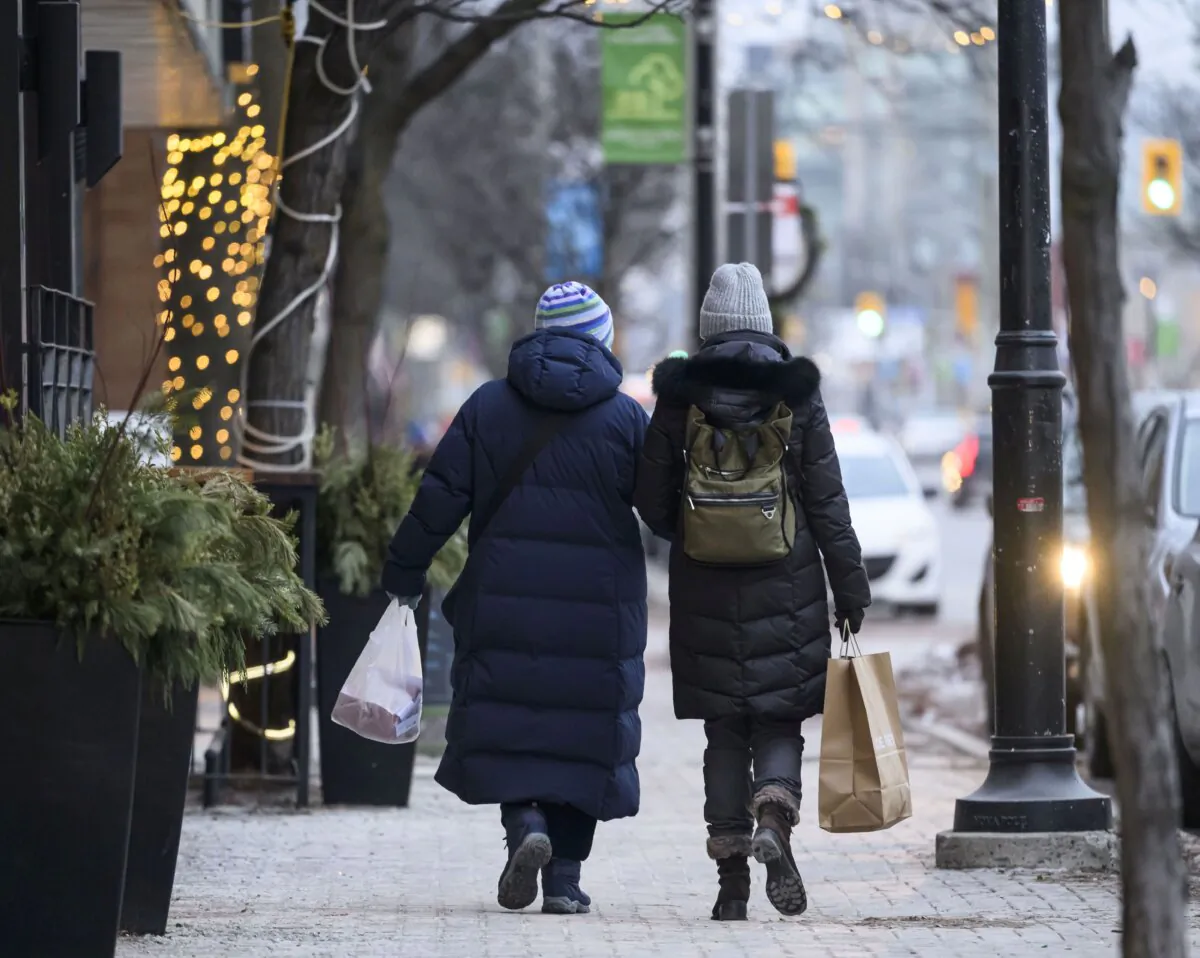 People stroll along a street in Ottawa's Westboro Village neighbourhood on Dec. 23, 2023. (The Canadian Press/Justin Tang)