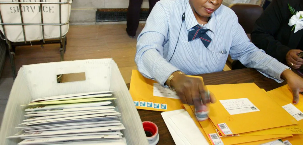 In a file photo, a postal worker is seen putting stamps on envelopes heading to the IRS  (Monika Graff/Getty Images)
