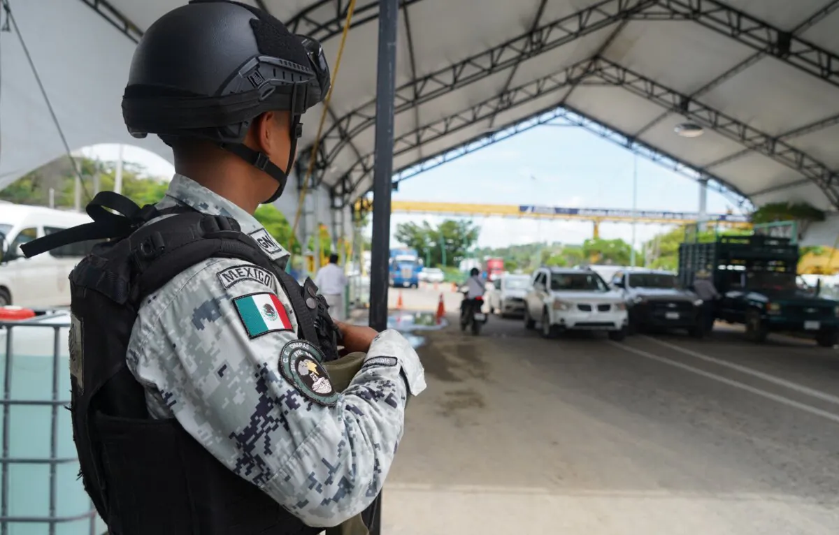 A member of the Mexican National Guard stands guard at a checkpoint near where relatives of a group of sixteen Chiapas state police administrative workers protest on the highway for the release of their kidnapped relatives in Chiapa de Corzo, Chiapas state, Mexico, on June 29, 2023. (Raul Mendoza/AFP via Getty Images)