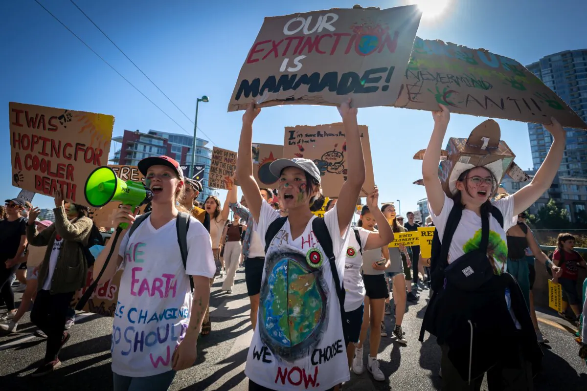 People march across the Cambie Bridge while chanting and cheering during the Global Climate Strike protest in Vancouver on Sept. 15, 2023. (The Canadian Press/Ethan Cairns)