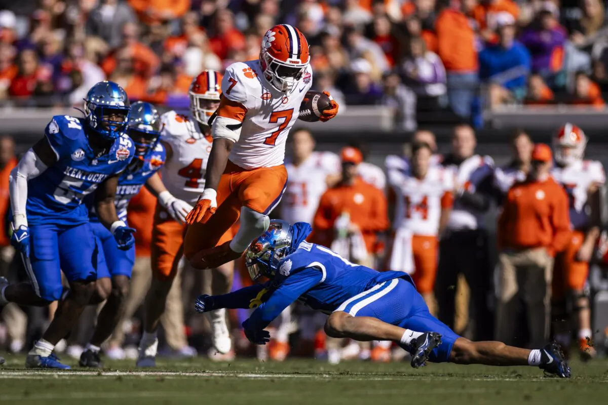 Phil Mafah (7) of the Clemson Tigers hurdles Zion Childress (11) of the Kentucky Wildcats during the first half of the TaxSlayer Gator Bowl in Jacksonville, Fla., on Dec. 29, 2023. (James Gilbert/Getty Images)