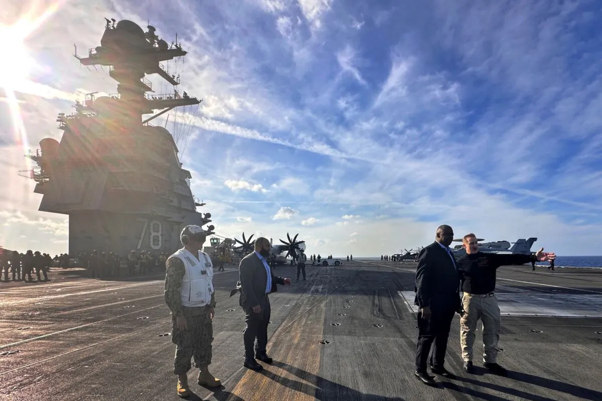 Defense Secretary Lloyd Austin, (2nd R), talks with the commanding officer of the USS Gerald R. Ford, Navy Capt. (Tara Copp/AP Photo)