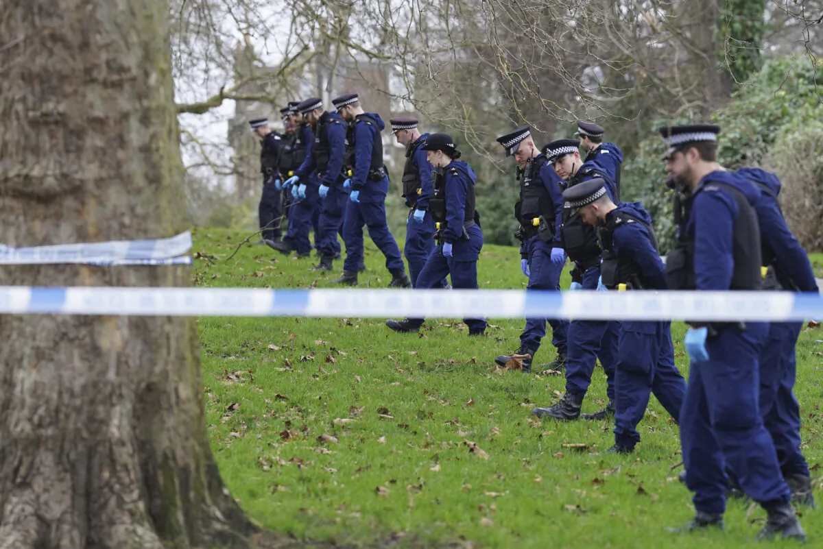 Police officers conduct a fingertip search on Primrose Hill where a teenage boy died after being stabbed just before midnight on New Year's Eve in London on Jan. 1, 2024. (Stefan Rousseau/PA via AP)