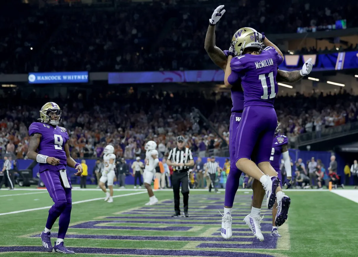 Jalen McMillan (11) of the Washington Huskies celebrates, as Michael Penix Jr. (9) arrives into the end zone, following a touchdown during the third quarter against the Texas Longhorns during the CFP Semifinal Allstate Sugar Bowl in New Orleans on Jan. 1, 2024. (by Jonathan Bachman/Getty Images)