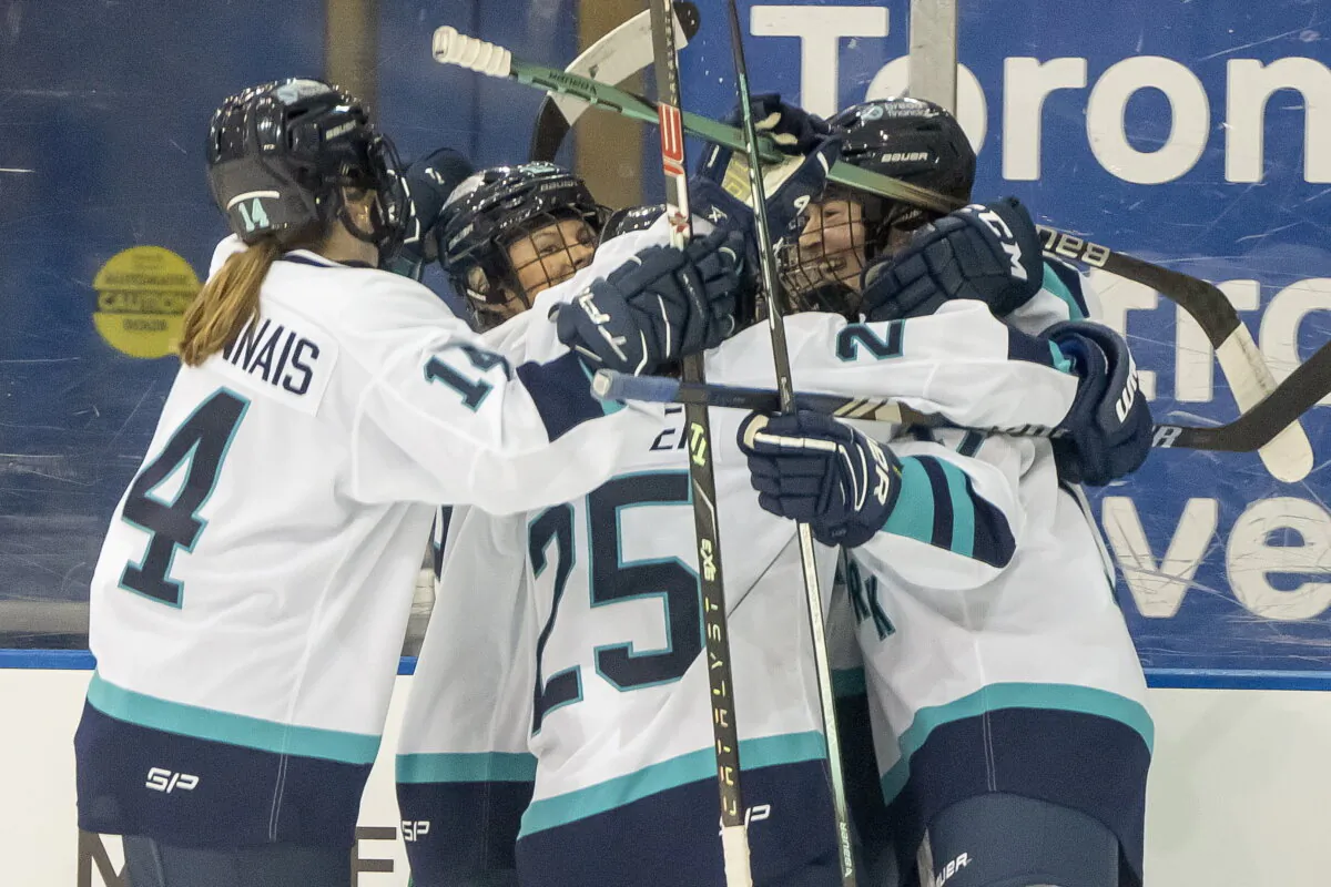 New York defender Ella Shelton, (R), is congratulated by teammates Jamie Bourbonnais (14), Paetyn Levis (19), and Alex Carpenter (25) after scoring the first goal in PWHL history against Toronto during first period hockey game in Toronto on Jan. 1, 2024.  (Frank Gunn/The Canadian Press via AP)