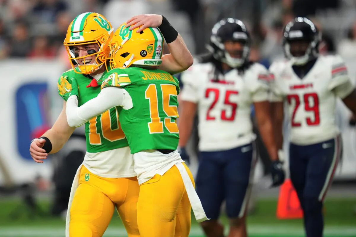 Oregon wide receiver Tez Johnson (15) celebrates his touchdown with quarterback Bo Nix (10) during the second half on the NCAA Fiesta Bowl college football game against Liberty in Glendale, Ariz., on Jan. 1, 2024. (Ross D. Franklin/AP Photo)